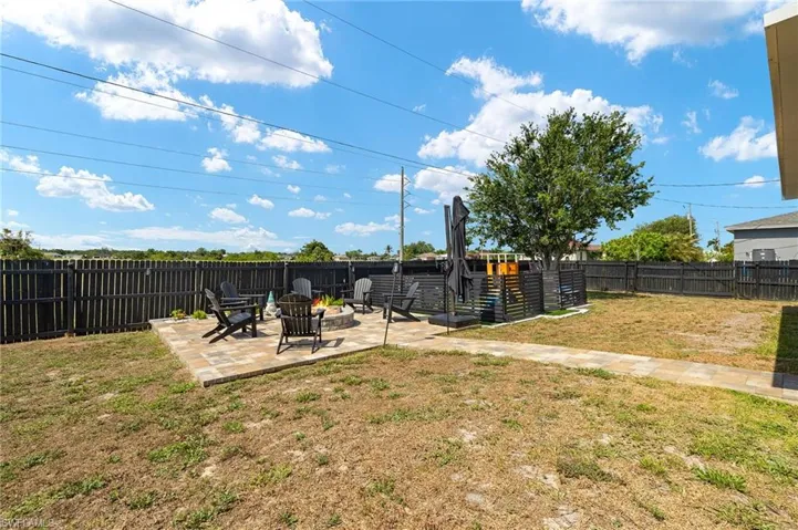 Fenced backyard featuring a patio area and a fire pit