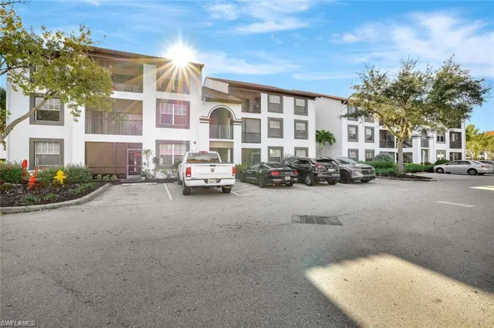 View of apartment building / complex with uncovered parking