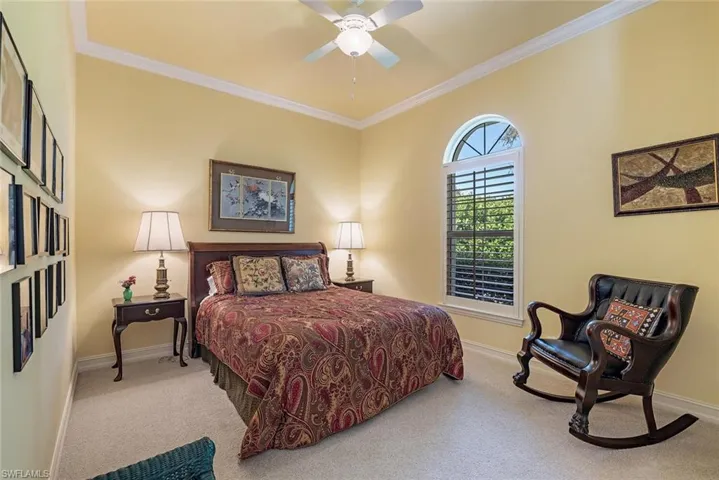 Guest bedroom featuring crown molding, light colored carpet, and ceiling fan