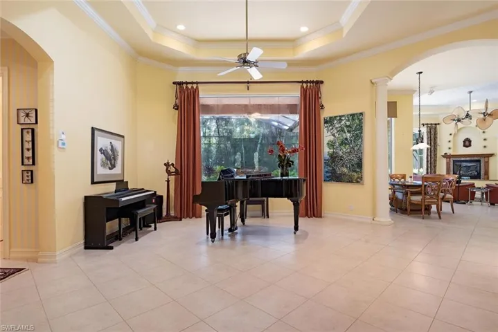 Living room. being used as a music room!  Features include  tray ceiling, crown molding, ceiling fan, and neutral tile flooring