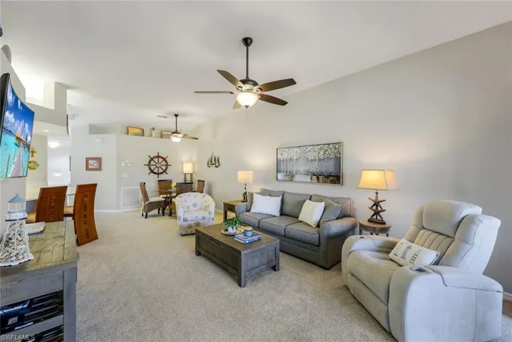 Gorgeous and light-filled living room with new ceiling fans, counter height bar in kitchen, and separate dining area