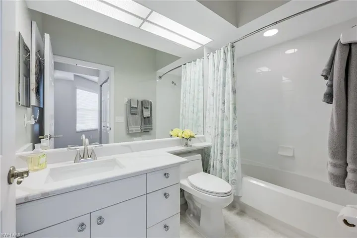 Guest bathroom with brand new (2025) quartz countertops with marble look, new toilets (2023), tile shower with tub combination.