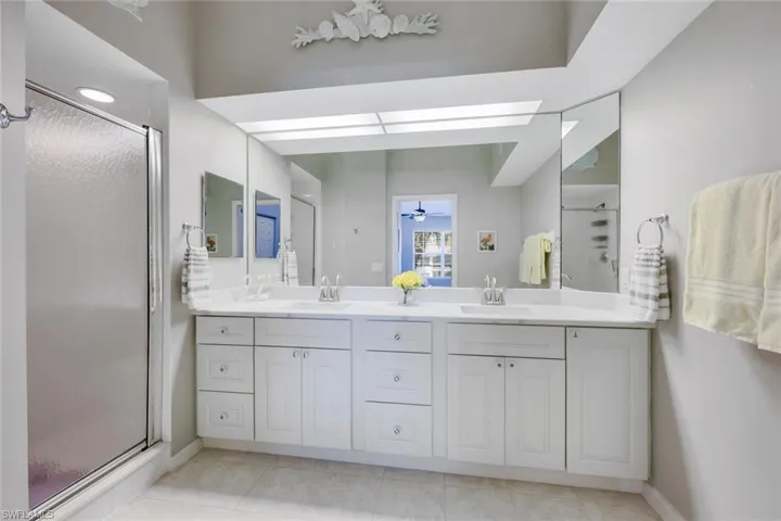 Spacious primary bathroom with double vanity, shower, brand new (2025) quartz bathroom counter tops with white marble look and new cabinetry.
