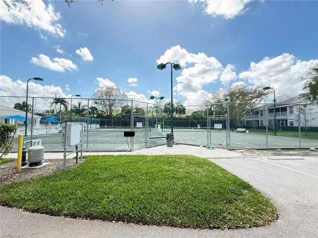 View of tennis court with a gate