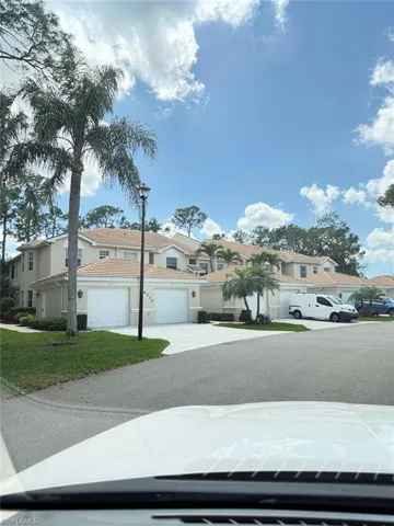 View of front of property featuring concrete driveway, a garage, stucco siding, and a residential view