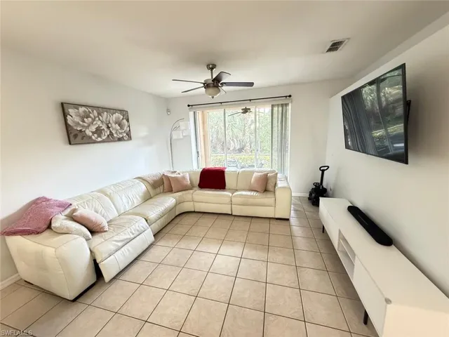 Living area featuring ceiling fan and light tile patterned floors