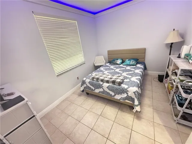 Bedroom with light tile patterned flooring and baseboards