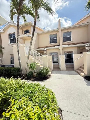 View of front of home featuring stucco siding and a balcony