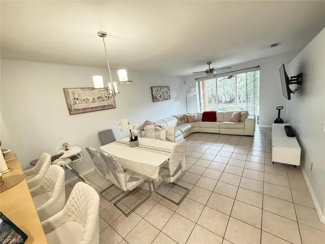Dining area with a ceiling fan, light tile patterned floors, and suspended lighting