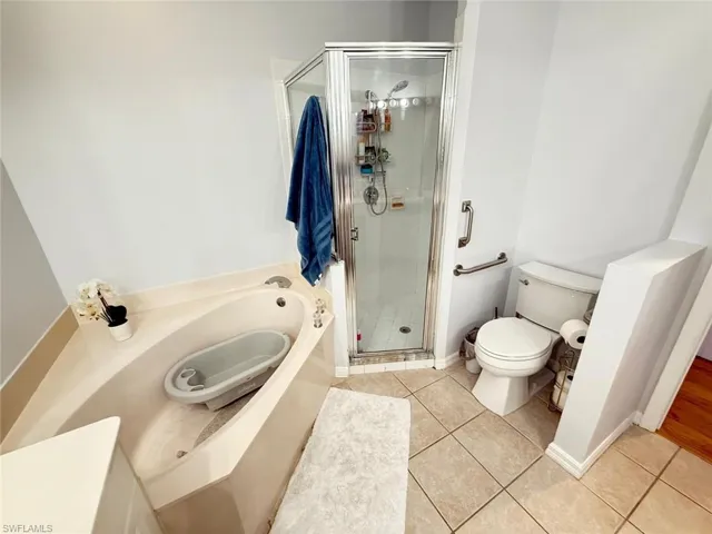 Full bathroom with a garden tub, a stall shower, and light tile patterned floors
