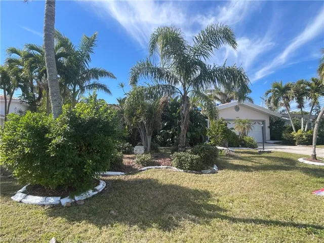 View of front facade featuring a garage and a front lawn
