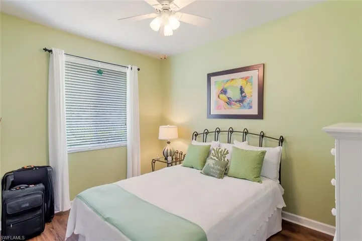 Bedroom with dark hardwood / wood-style floors and ceiling fan