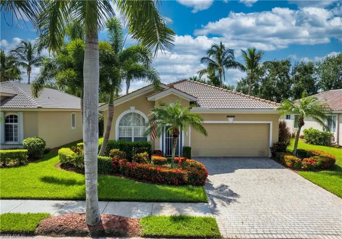 Mediterranean / spanish-style home featuring a garage and a front lawn