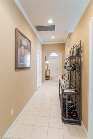 Hallway with tile floors and ornamental molding