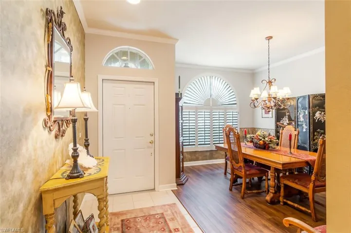 Entryway featuring ornamental molding, an inviting chandelier, and hardwood / wood-style floors