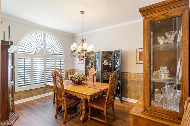 Dining area featuring a chandelier, dark hardwood / wood-style floors, and ornamental molding