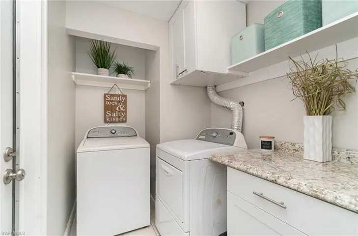 Indoor laundry room  with cabinets and washing machine and clothes dryer