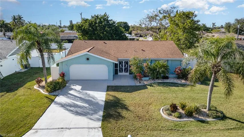 Ranch-style home with a garage and a front lawn