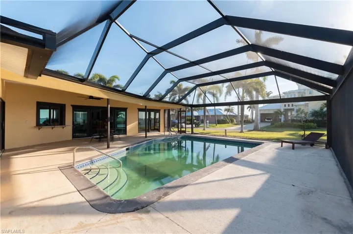 Pool with a patio, a yard, and a lanai