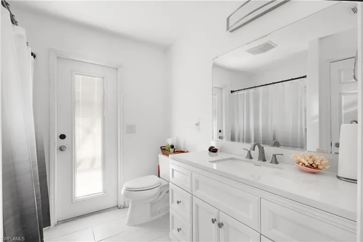 Bathroom with toilet, vanity, and visible vents