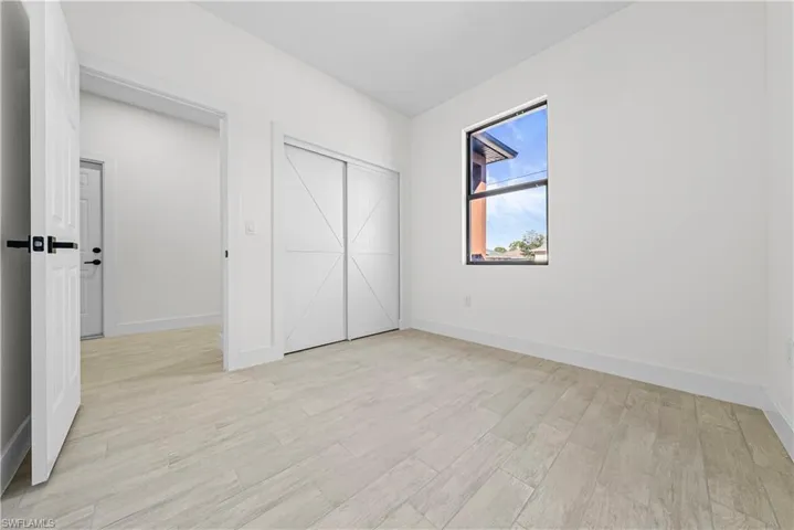 Unfurnished bedroom featuring light wood-type flooring and a closet