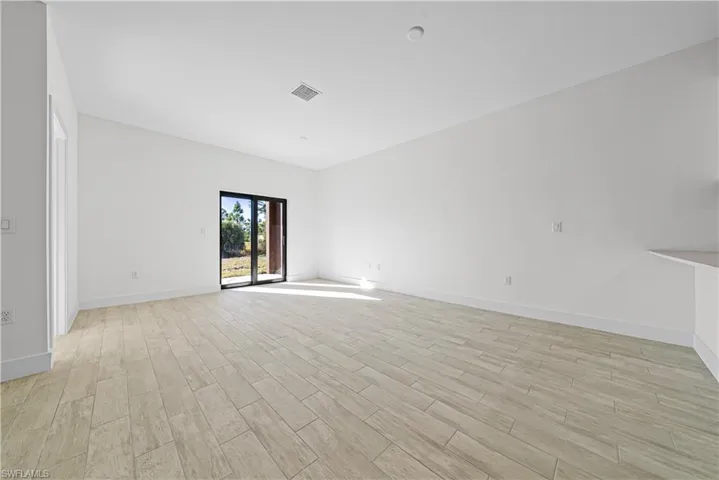 Unfurnished room featuring wood tiled floors and baseboards