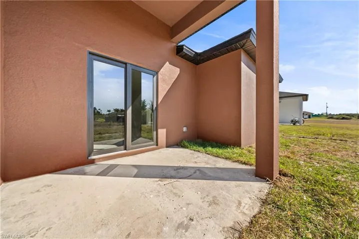 Back of property with stucco siding and a patio