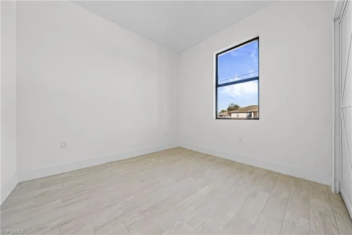 Unfurnished room featuring light wood-type flooring and baseboards