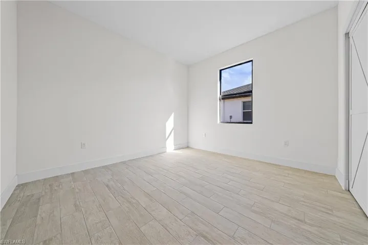 Unfurnished room featuring wood finish floors and baseboards