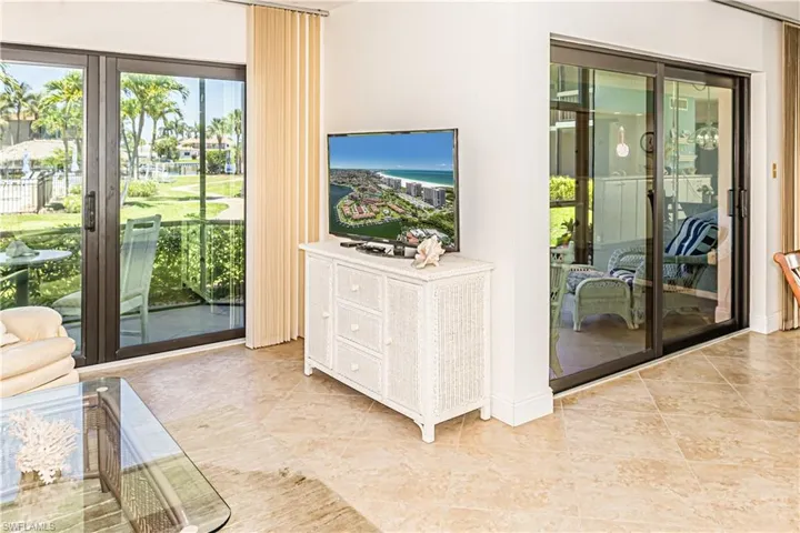 Doorway to outside with light tile patterned flooring and baseboards