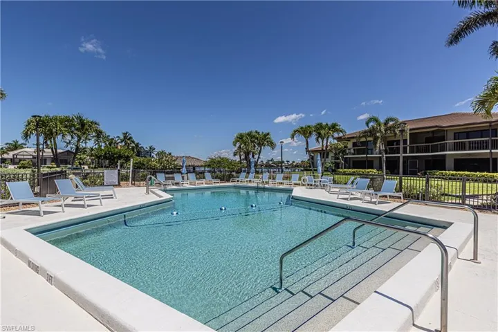 Community pool with fence and a patio area
