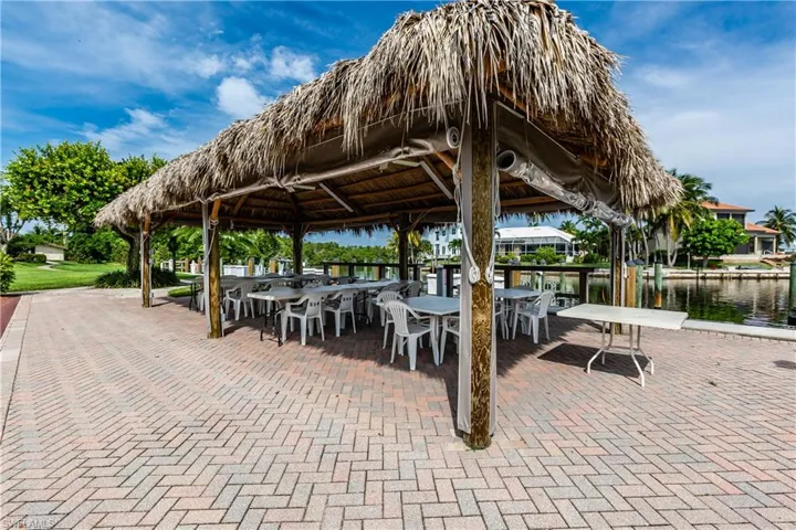 View of community featuring a gazebo, outdoor dining space, and a water view
