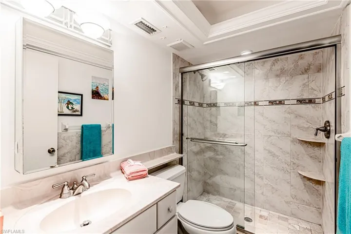 Full bath featuring toilet, a stall shower, and vanity