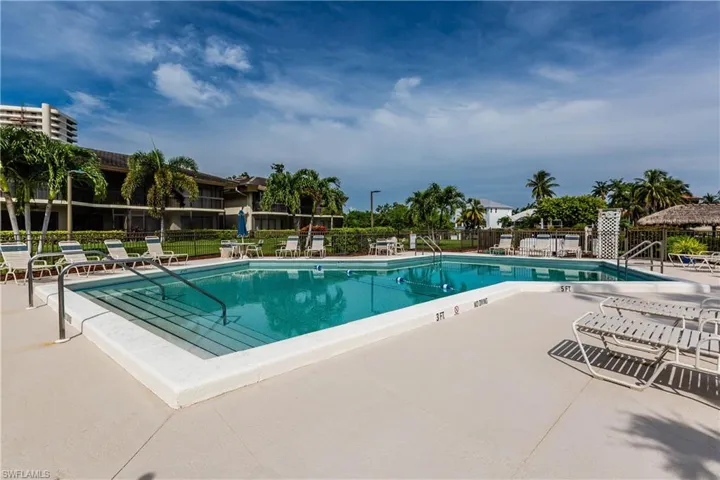 Community pool featuring fence and a patio area