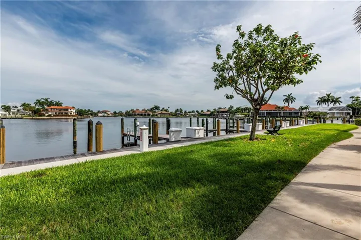 Dock featuring a lawn and a water view