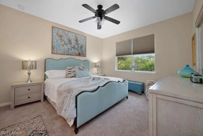 Bedroom with ceiling fan and light carpet