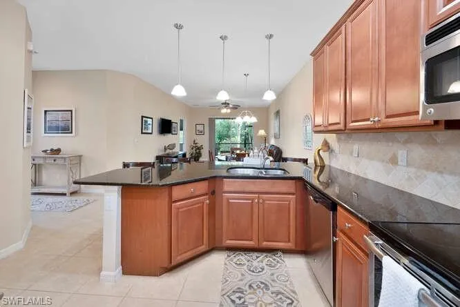Kitchen featuring kitchen peninsula, stainless steel appliances, ceiling fan, and sink