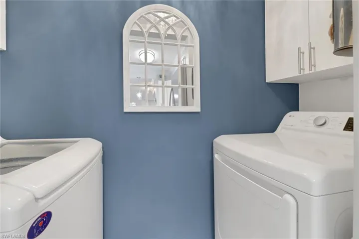 Laundry room featuring cabinets and washing machine and dryer