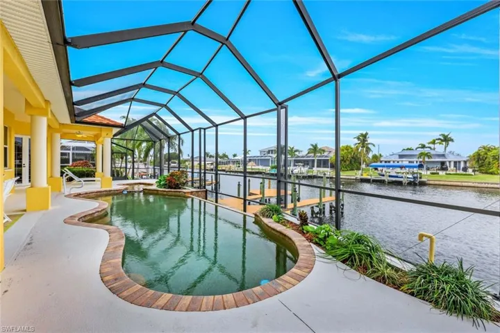 View of swimming pool featuring a water view, a boat dock, and a lanai