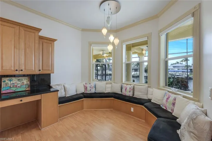 Kitchen featuring backsplash, crown molding, hanging light fixtures, and light wood-type flooring