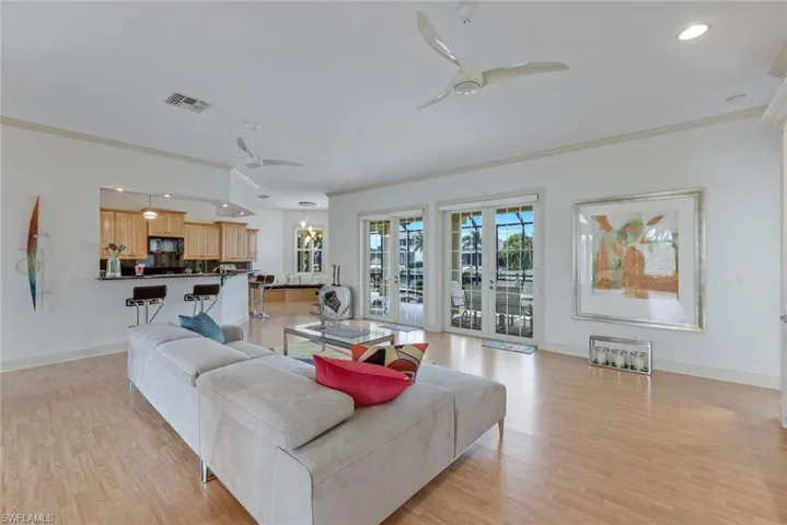 Living room with ceiling fan, crown molding, and light hardwood / wood-style floors
