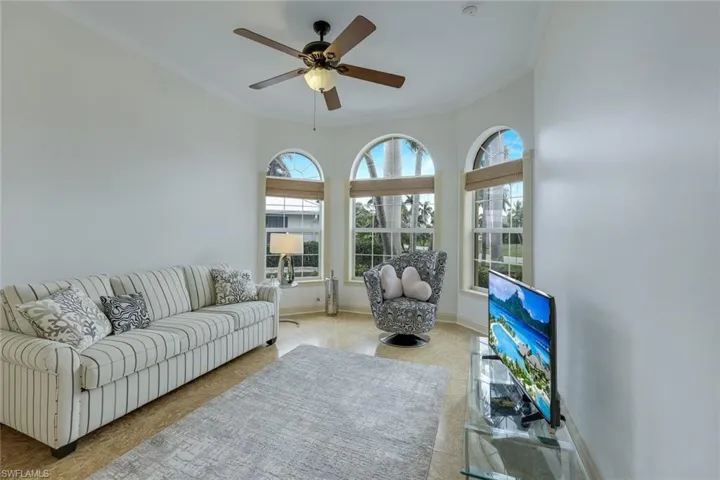 Living room with ceiling fan and ornamental molding