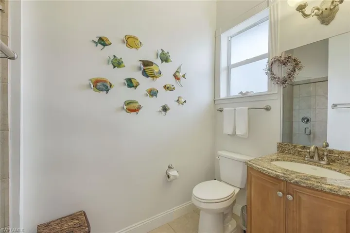 Bathroom featuring vanity, toilet, tile patterned floors, and tiled shower
