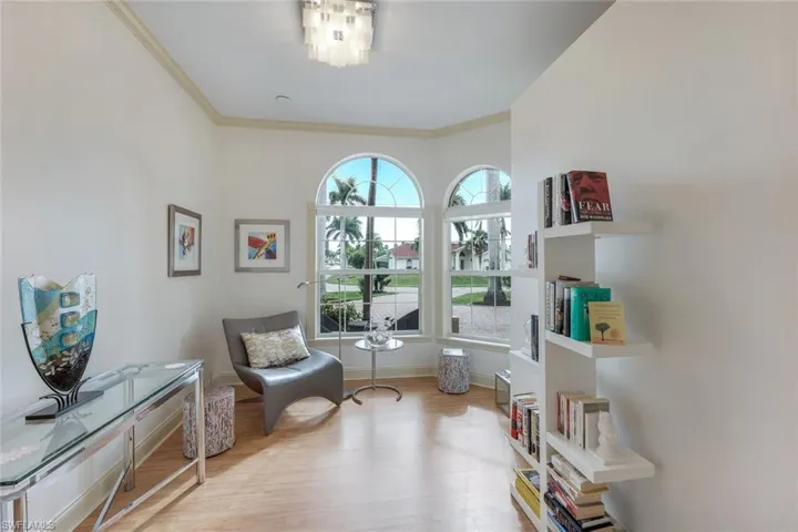 Living area featuring ornamental molding and light wood-type flooring
