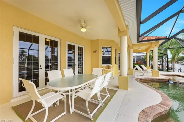 View of patio / terrace featuring glass enclosure, ceiling fan, and french doors