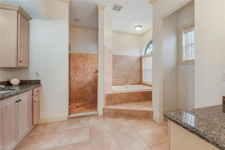 Bathroom featuring tile patterned flooring, vanity, independent shower and bath, and ornamental molding