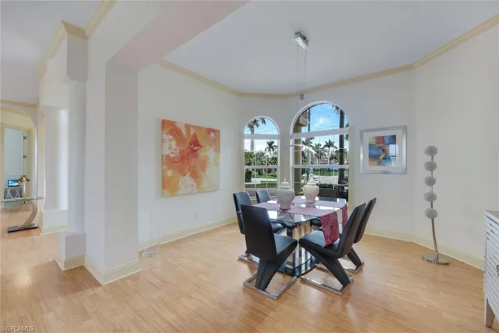 Dining area with light hardwood / wood-style floors and ornamental molding
