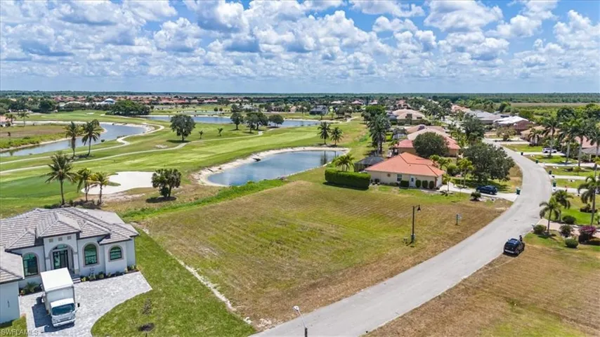 Aerial perspective of suburban area featuring a nearby body of water and a golf course