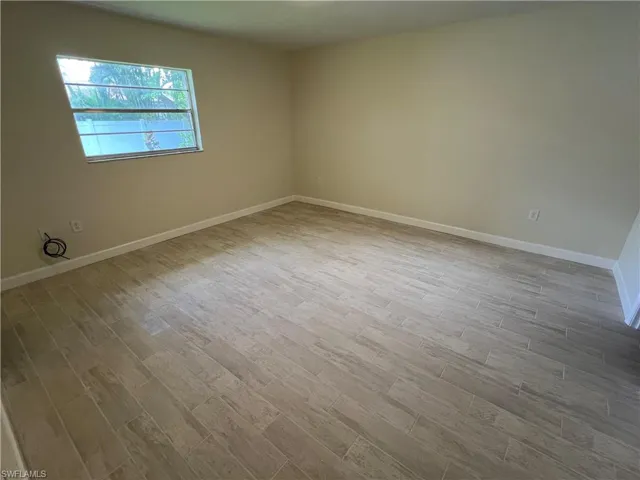 Empty room with hardwood / wood-style floors