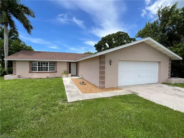 Ranch-style house with a garage and a front yard
